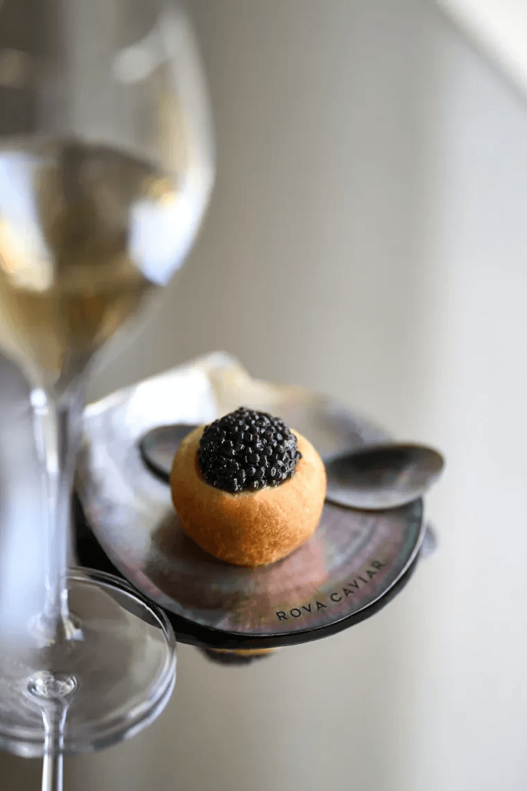 Appetizer bite service on mother-of-pearl dish with champagne glass