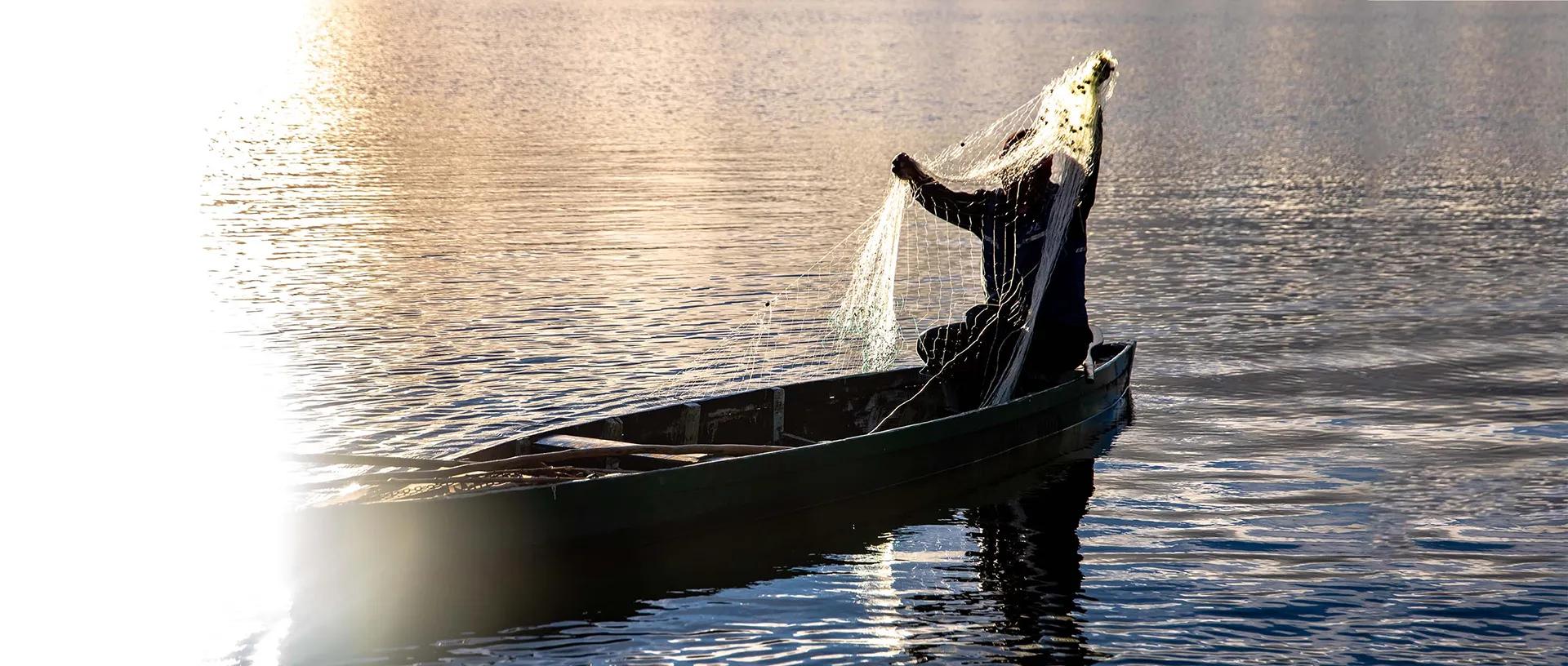 Fisherman with a net on a canoe