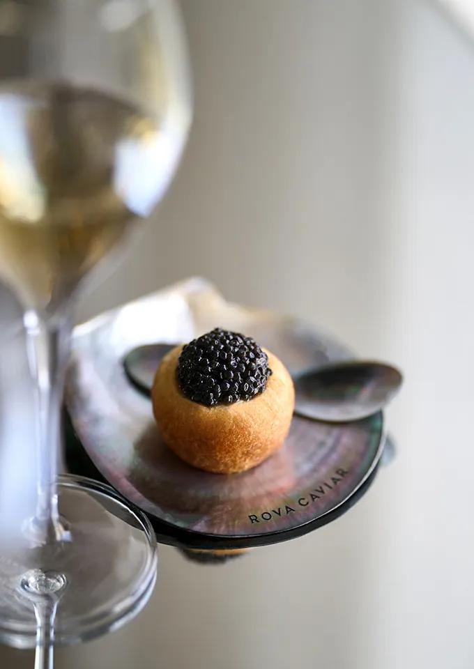 Appetizer bite service on mother-of-pearl dish with champagne glass