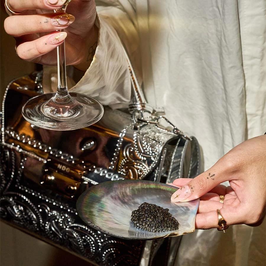 Close-up of a caviar tasting accompanied by a glass of champagne