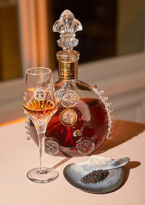 Louis XIII Cognac service with a glass of cognac, a spoon, and a mother-of-pearl spoon