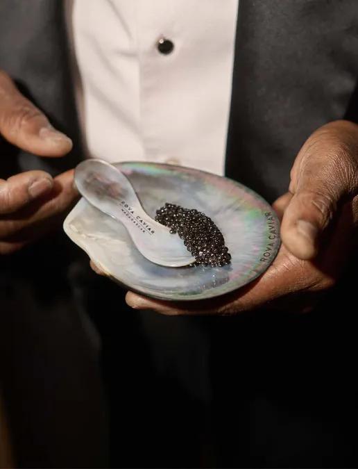 Caviar sur coupelle en nacre tenue dans les mains