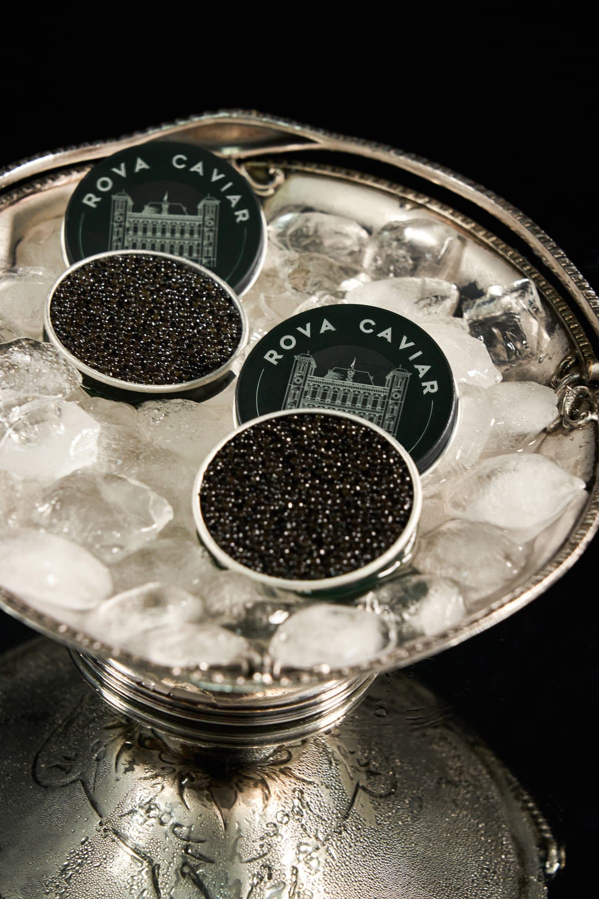 Two open Rova Caviar tins on crushed ice in a silver bowl